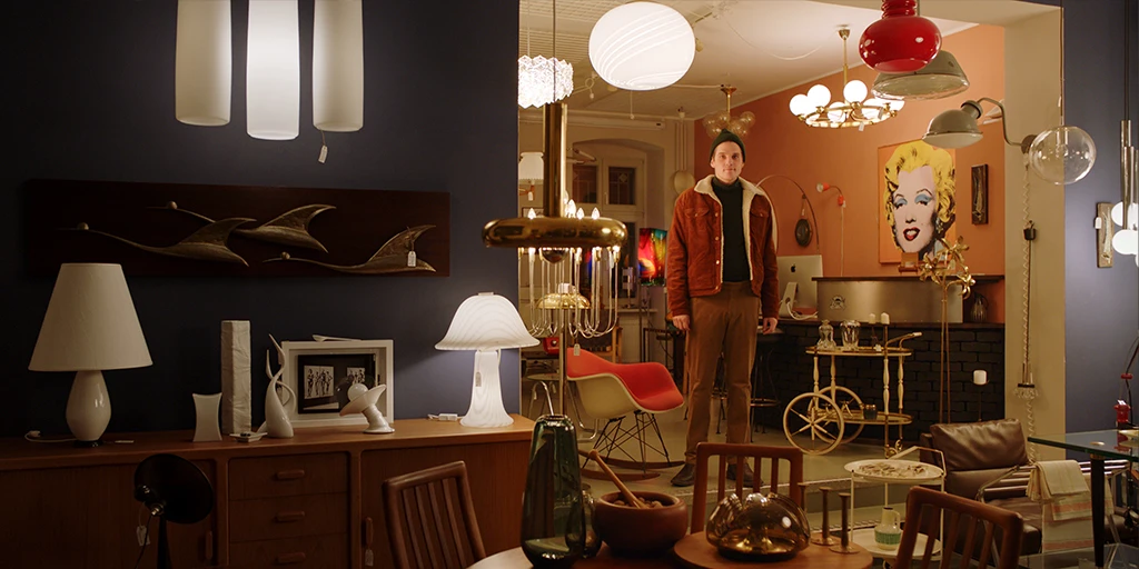 Louis (Benjamin Lillie) steht in einem Vintage Einrichtungsgeschäft und schaut sich um. Aufgeweckt blickt er in Richtung Kamera im Werbespot »True Romance«.