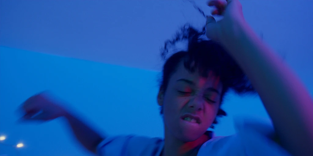 Lena (Shari Asha Crosson) tanzt ausgelassen im Spielfilm Â»Die Mathematik der DingeÂ« in farbigem Licht